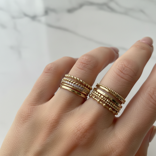 14kt gold stackable rings in various band styles stacked on a hand